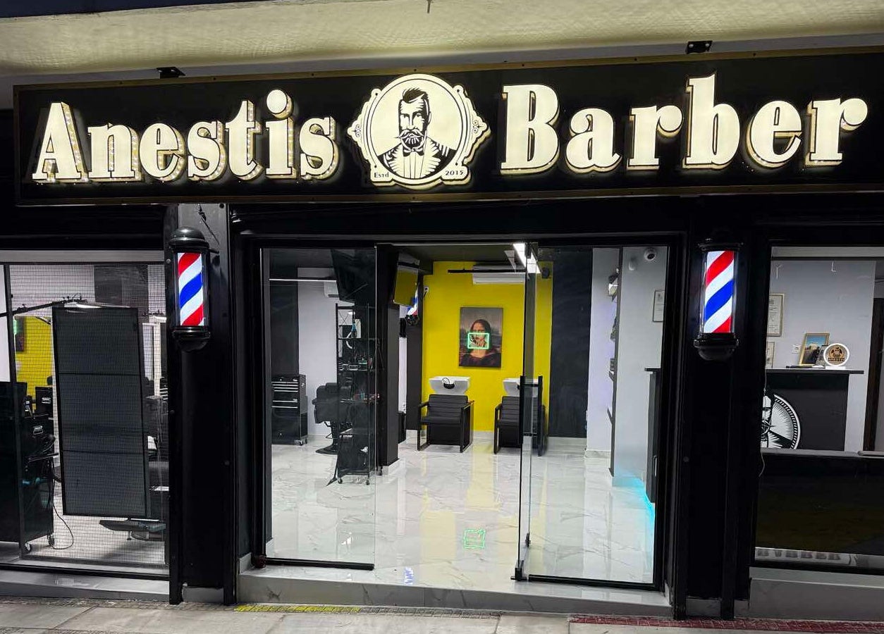 Η πρόσοψη του Anestis Barber στην Αγία Βαρβάρα, GR με φωτεινή επιγραφή και μοντέρνα διακόσμηση.