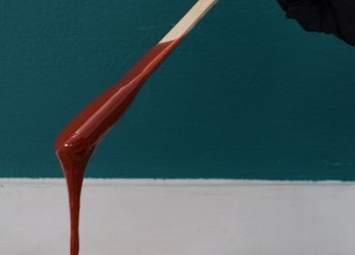 Brown wax drip on stick at Empire Nails and Beauty Studio, Sandton, Gauteng, ZA. Aesthetic wax services.