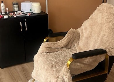Luxury treatment chair at Beauty Couture & Aesthetic Salon, Leicester, England, GB, with plush throw and products.