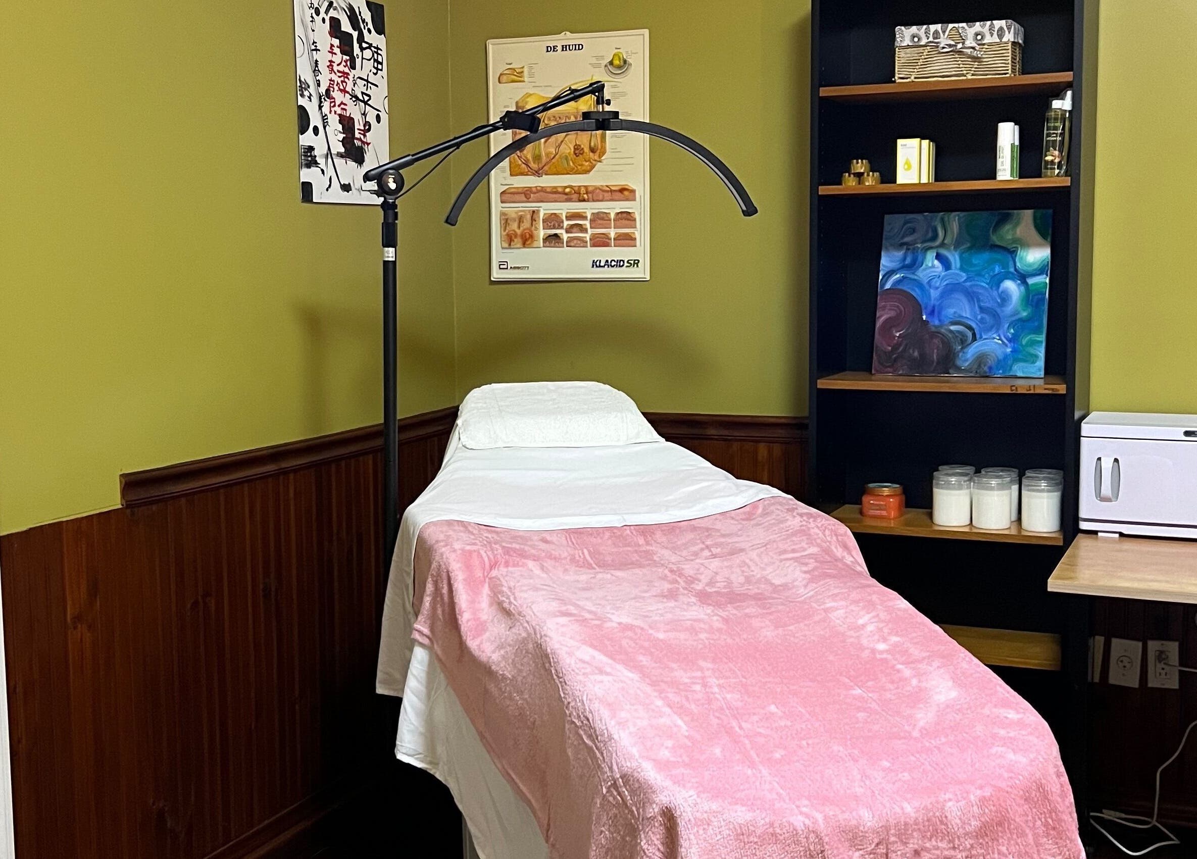 Massagekamer bij Marilyn's Wax and Beauty Salon in Paramaribo, Paramaribo, SR met roze bed en producten.