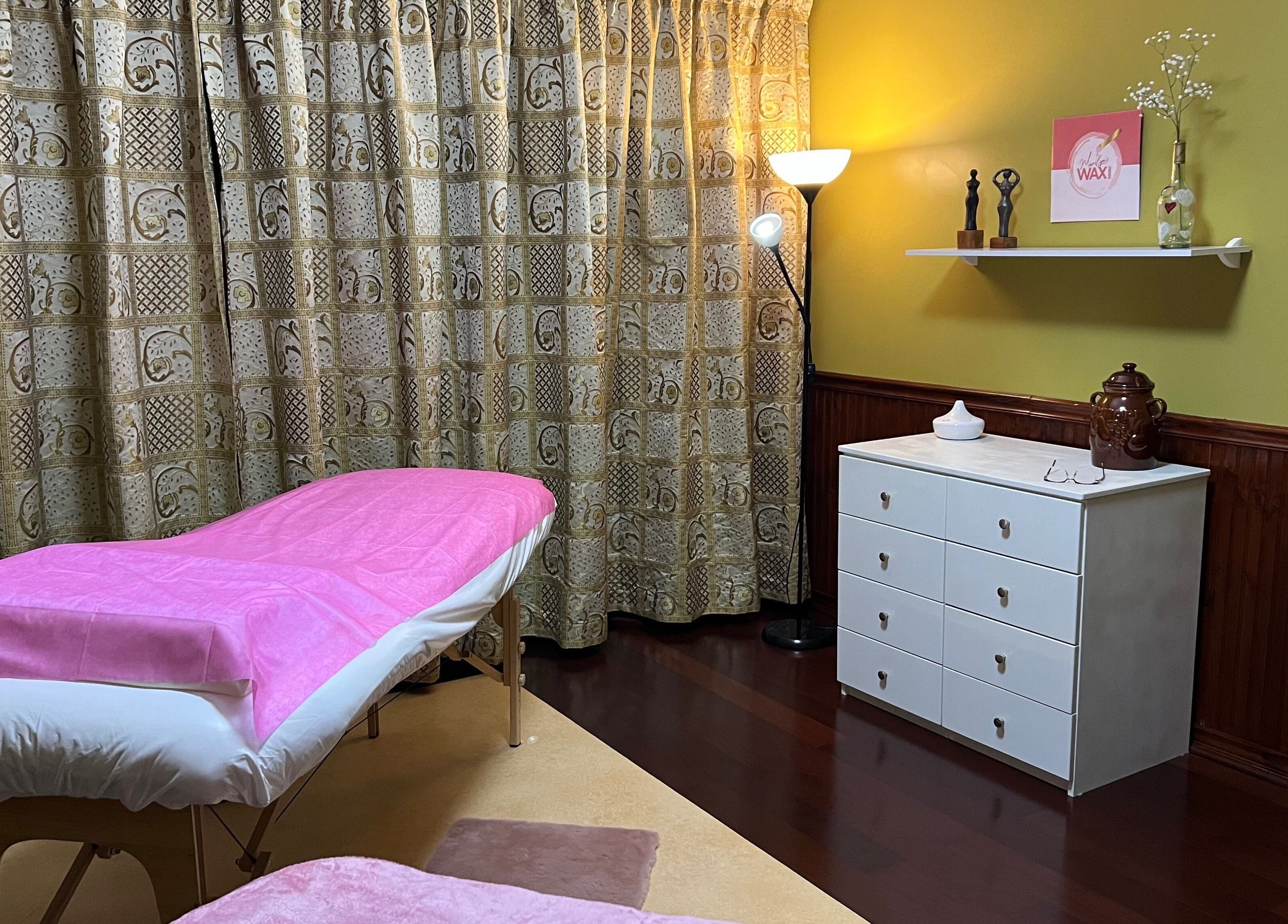 Stijlvolle behandelkamer bij Marilyn's Wax and Beauty Salon in Paramaribo, Paramaribo, SR met roze details.