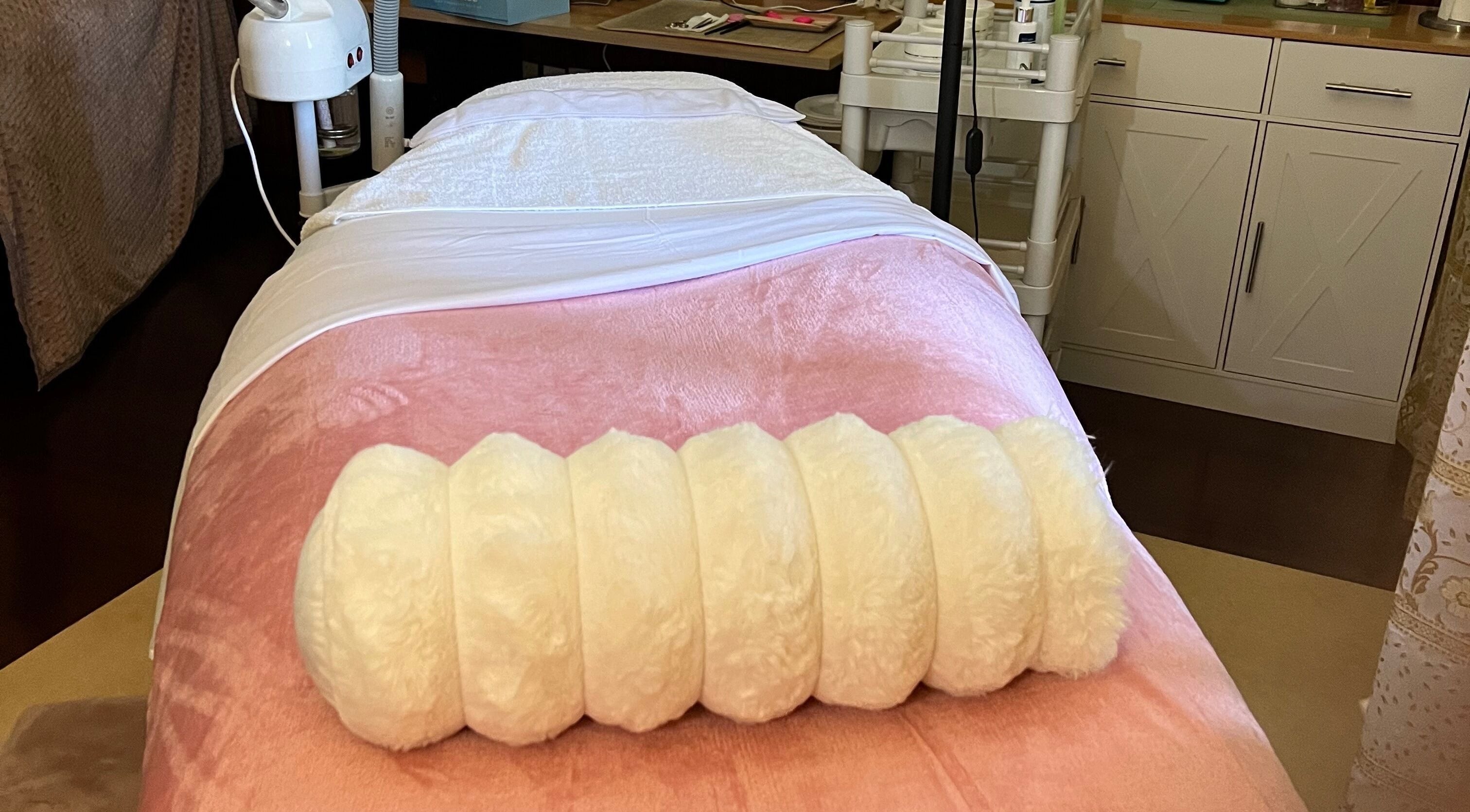 Behandelbed in Marilyn's Wax and Beauty Salon, Paramaribo, Paramaribo, SR met roze en witte bekleding.
