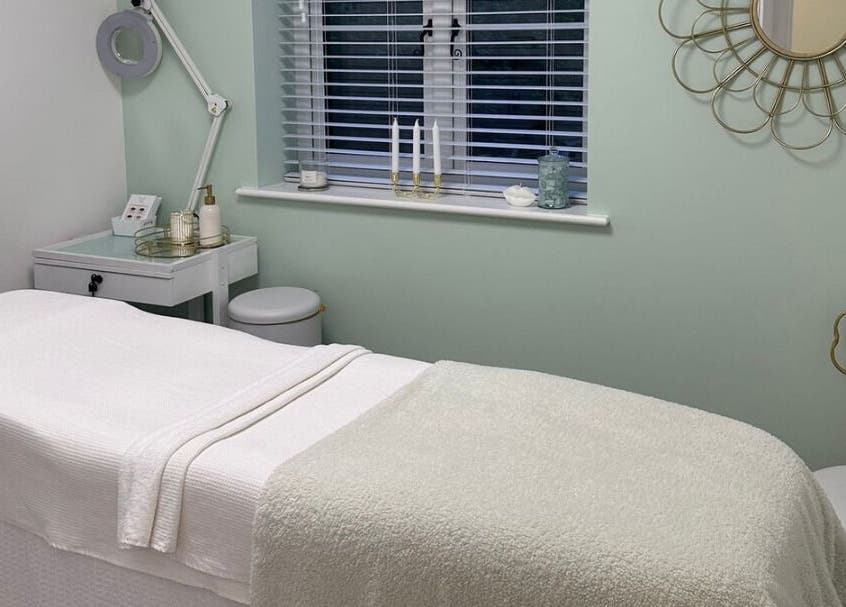 Pure Cosmetics, Botley, England spa room with a treatment bed, mirror, and soothing decor.