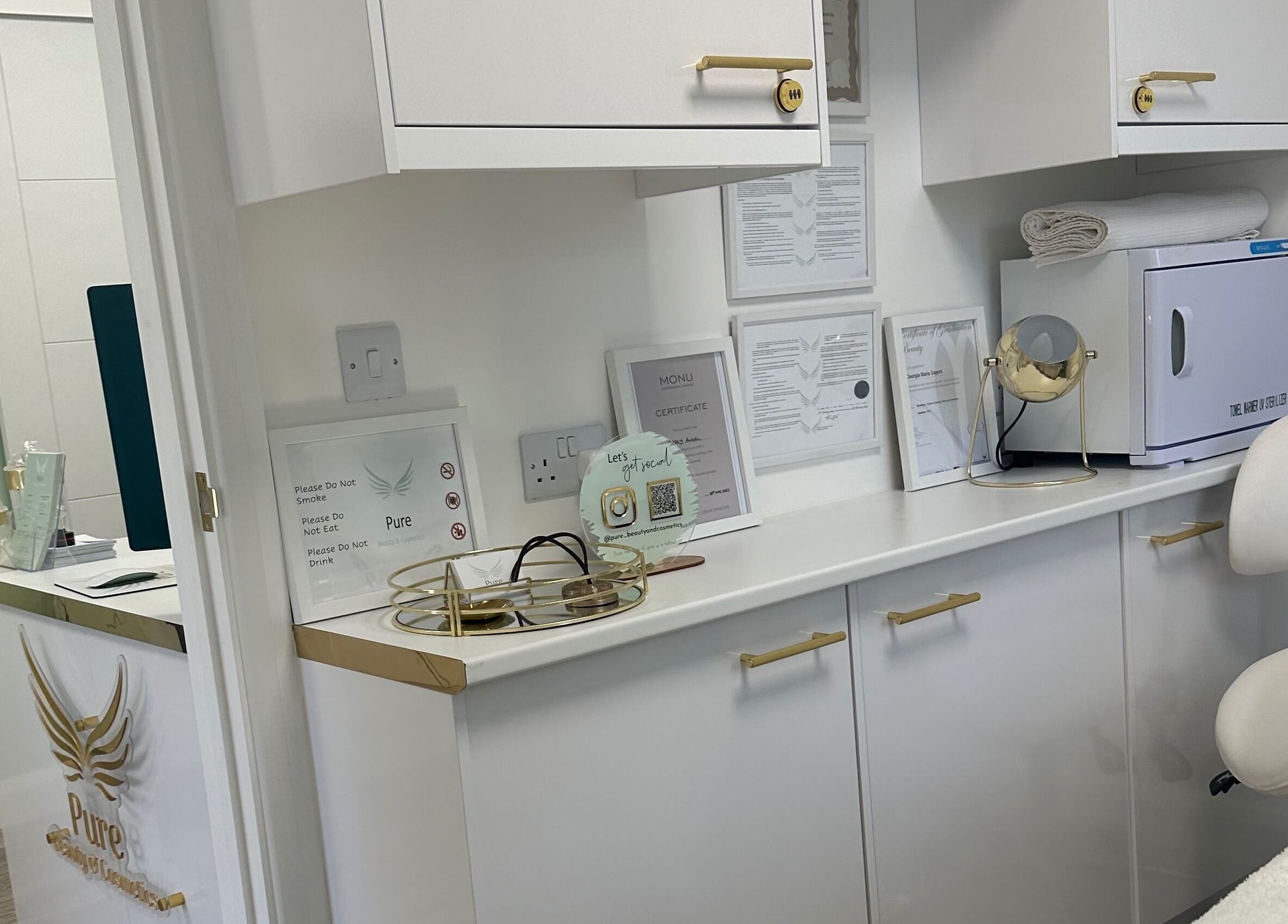 Cozy treatment room at Pure Cosmetics, Botley, England, featuring elegant white decor and golden accents.
