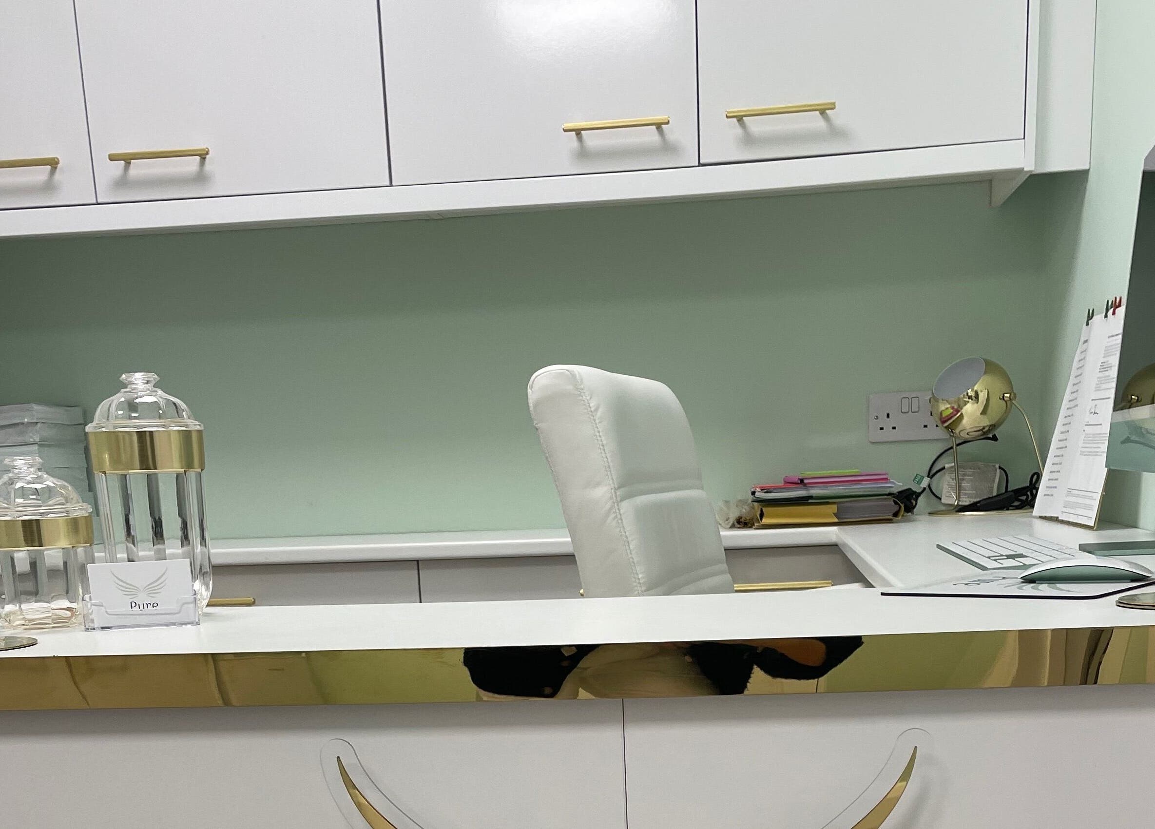 Stylish desk area at Pure Cosmetics, Botley, England. Elegant white and gold decor with modern office essentials.