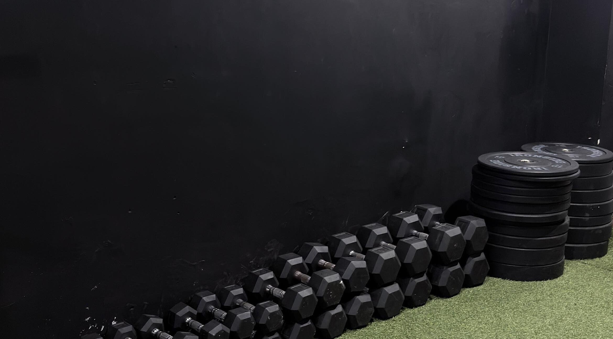 Área de pesas en ALLSTAR FITNESS, Mérida, Yucatán, MX, mostrando mancuernas y discos apilados.