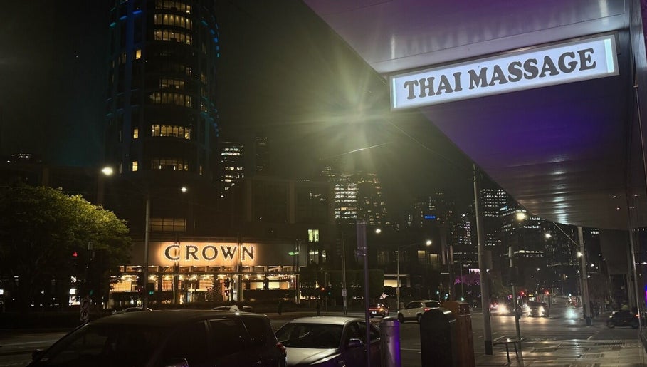 ElE Thai Massage sign glowing at night in Victoria, Victoria, AU with city lights in the background.