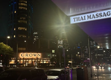 ElE Thai Massage sign glowing at night in Victoria, Victoria, AU with city lights in the background.