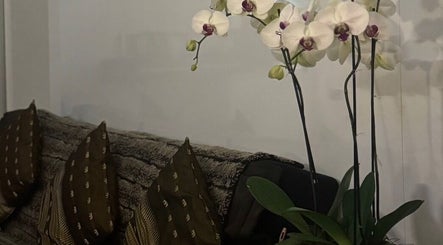 Elegant orchids by cozy sofa at ElE Thai Massage, Victoria, AU, blending comfort and tranquility.