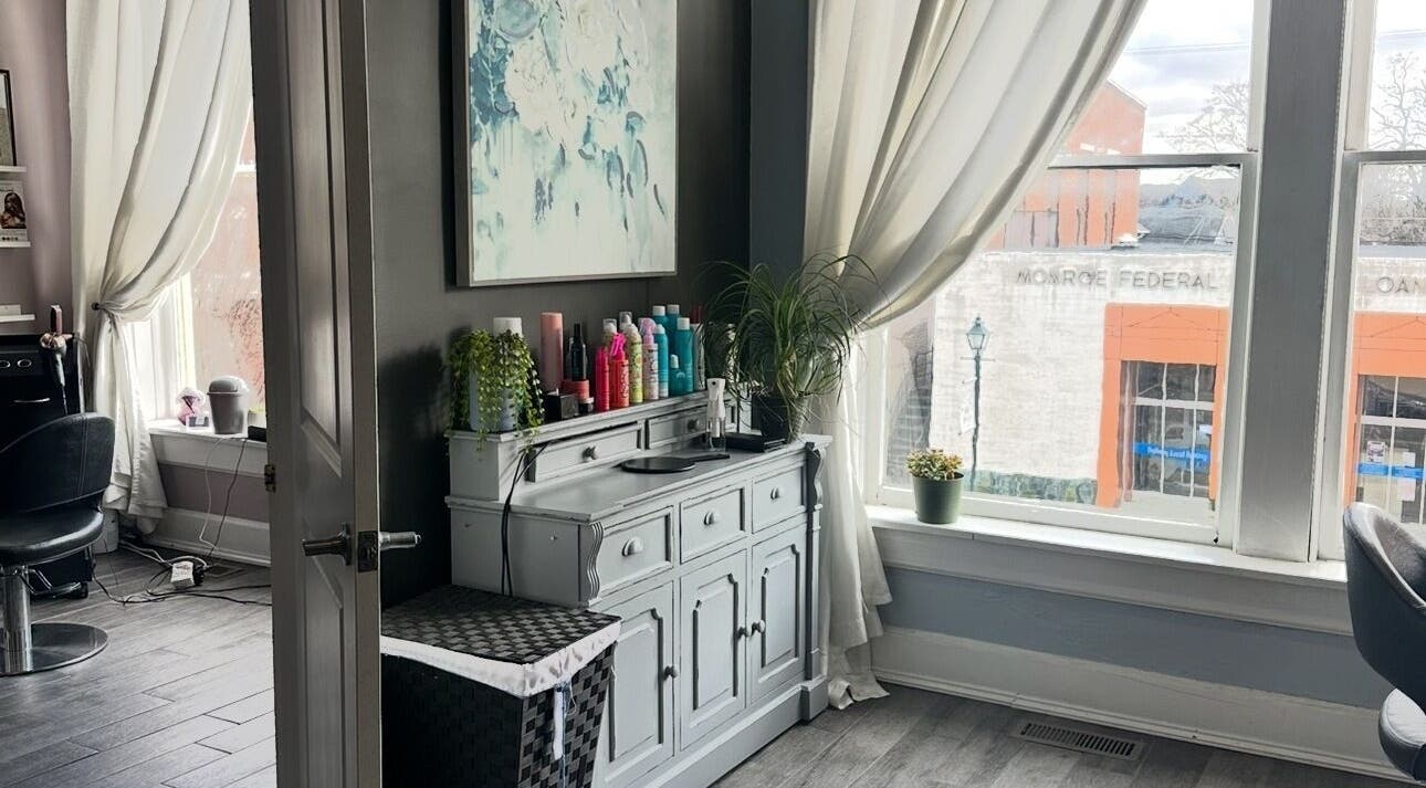 Bright, stylish salon space at Hair by Hillary, Tipp City, Ohio, US featuring modern decor and large windows.