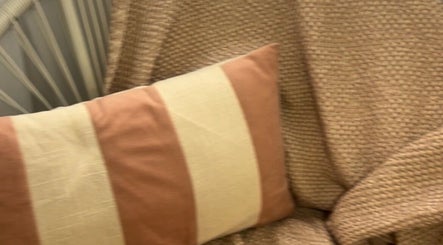 Cozy corner with a striped pillow and textured throws at The Lady Cave, Palmerston North, Manawatū-whanganui Region, NZ.