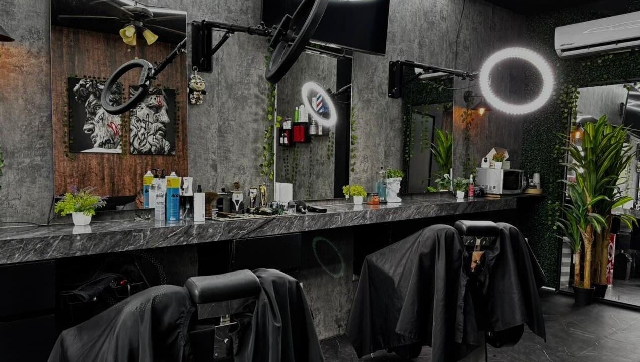 Interior moderno de Olimpo Barber & Studio en Mazatlán, Sinaloa, MX con asientos y espejos sofisticados.