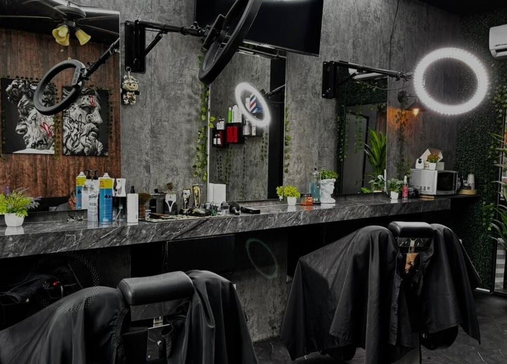 Interior moderno de Olimpo Barber & Studio en Mazatlán, Sinaloa, MX con asientos y espejos sofisticados.