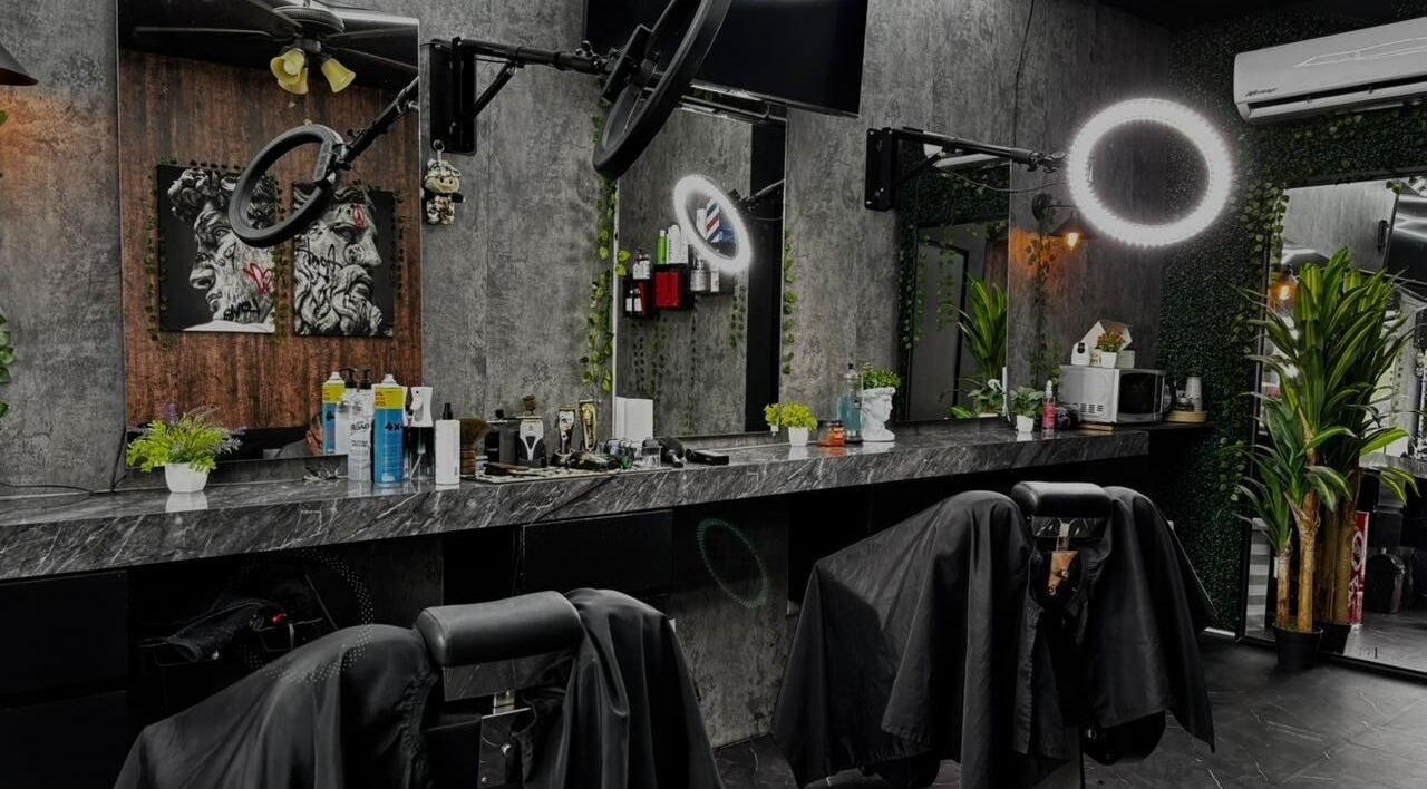 Interior moderno de Olimpo Barber & Studio en Mazatlán, Sinaloa, MX con asientos y espejos sofisticados.