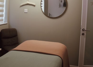 Cozy treatment room at Antonia Formosa Skin Therapist, St Julian's, MT, with a massage table and mirror.