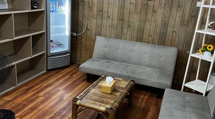 Ruang tunggu nyaman di Barberhop, Sumatera Utara, ID dengan sofa abu-abu dan dekorasi kayu.