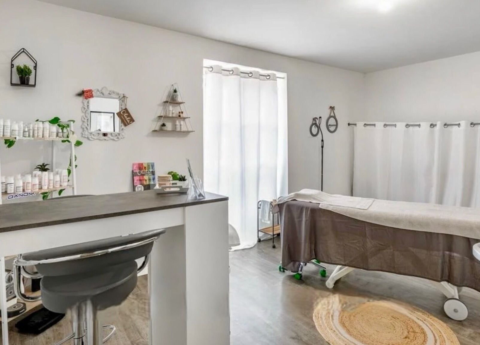 Salle de massage moderne à Sp Esthetique, Theuville, Île-de-France, FR avec lit de soins et produits beauté.