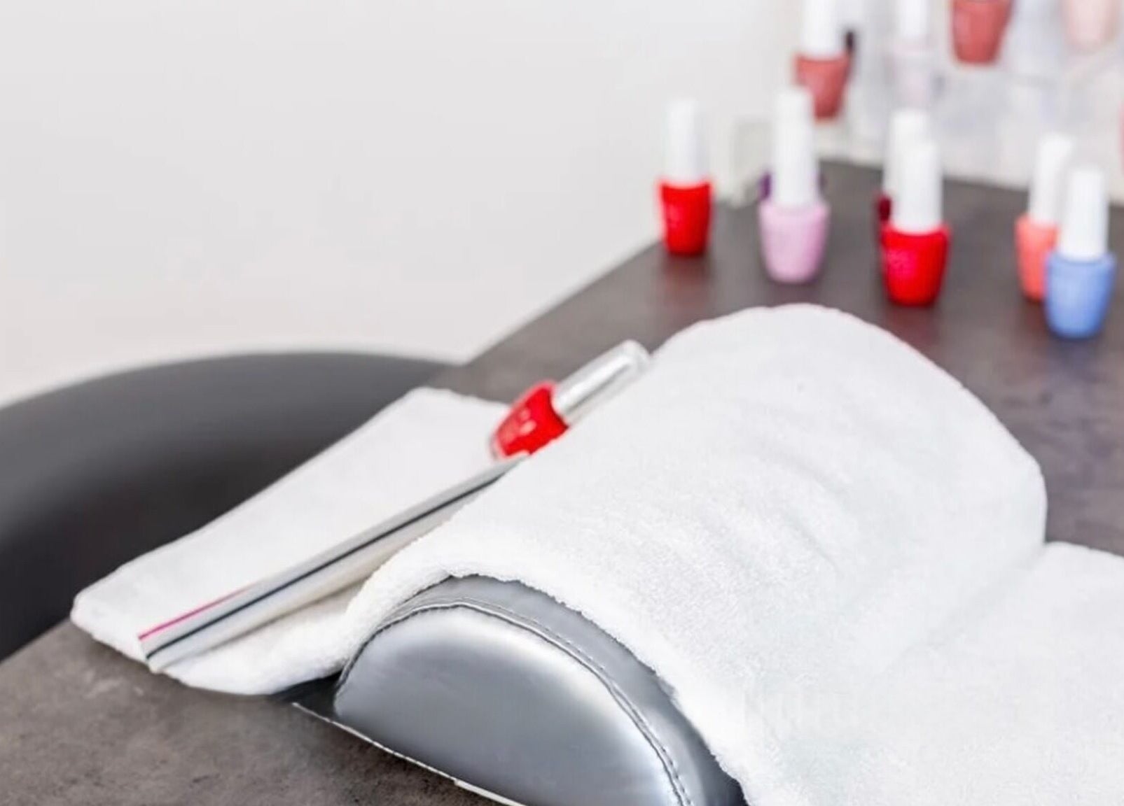 Table de manucure chez Sp Esthetique à Theuville, Île-de-France, avec vernis colorés prêts pour un soin des ongles.