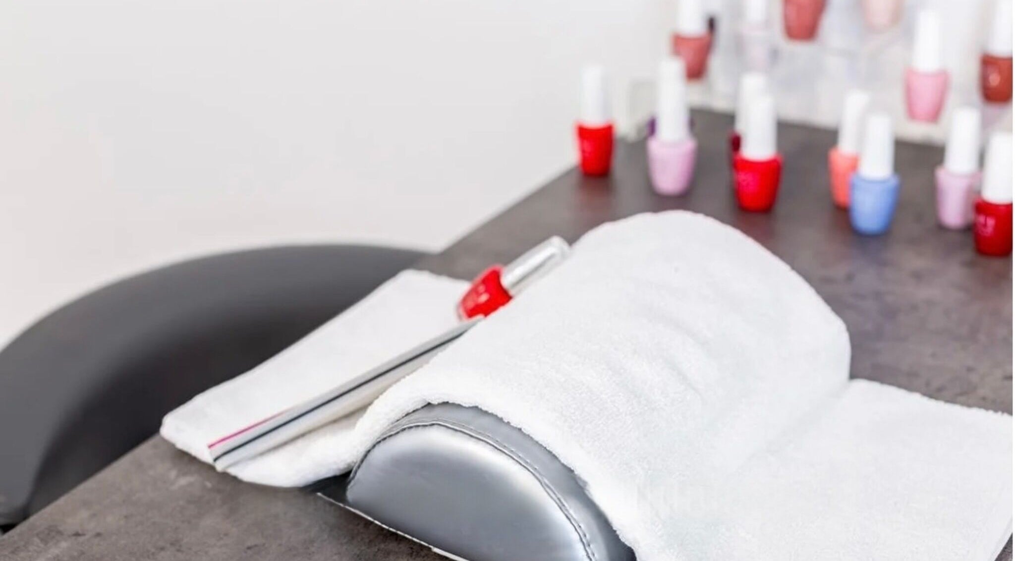 Table de manucure chez Sp Esthetique à Theuville, Île-de-France, avec vernis colorés prêts pour un soin des ongles.