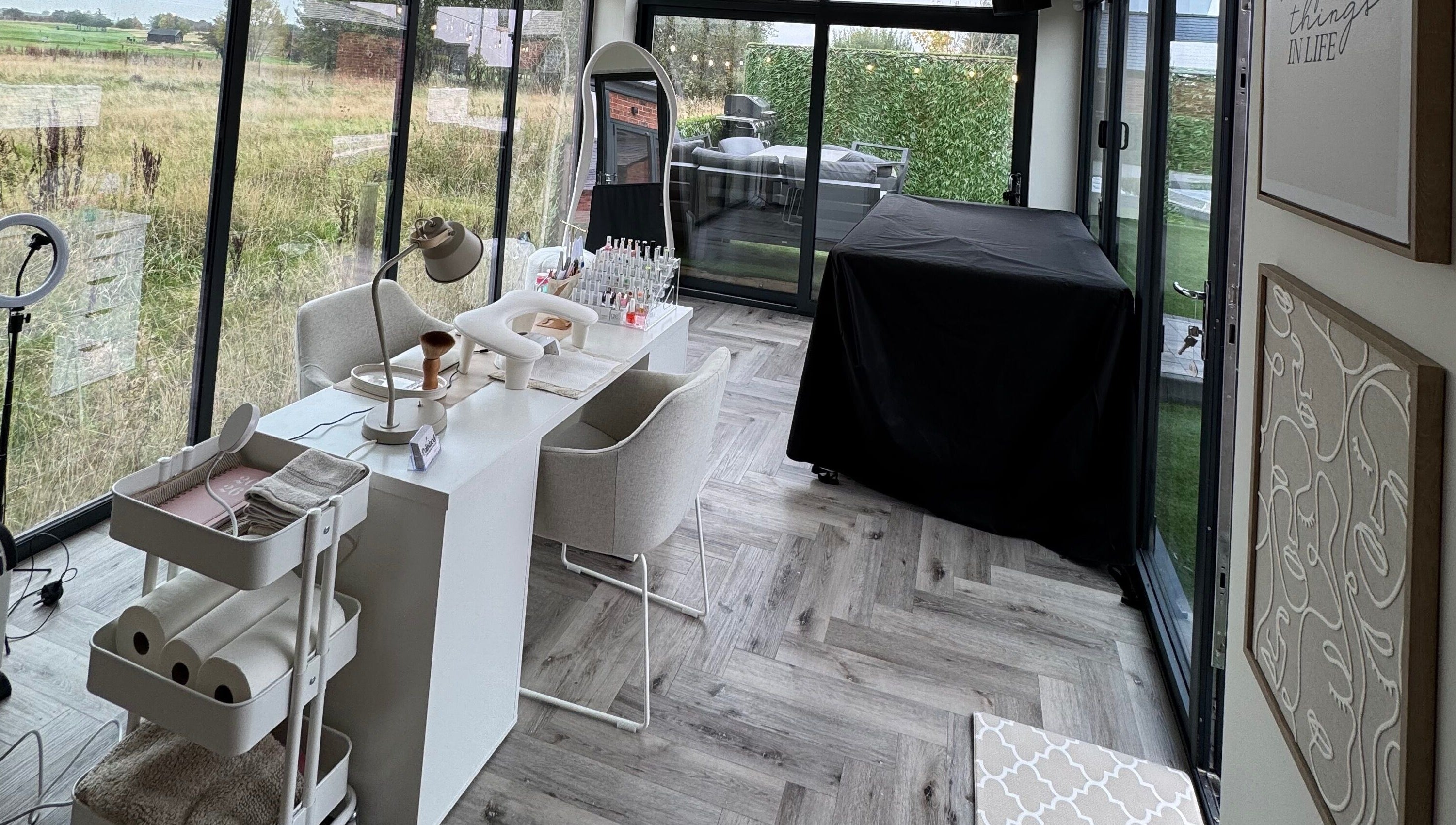 Chic nail studio setup at Polished By Poppy, Unsworth, England, GB, with modern decor and lush garden views.