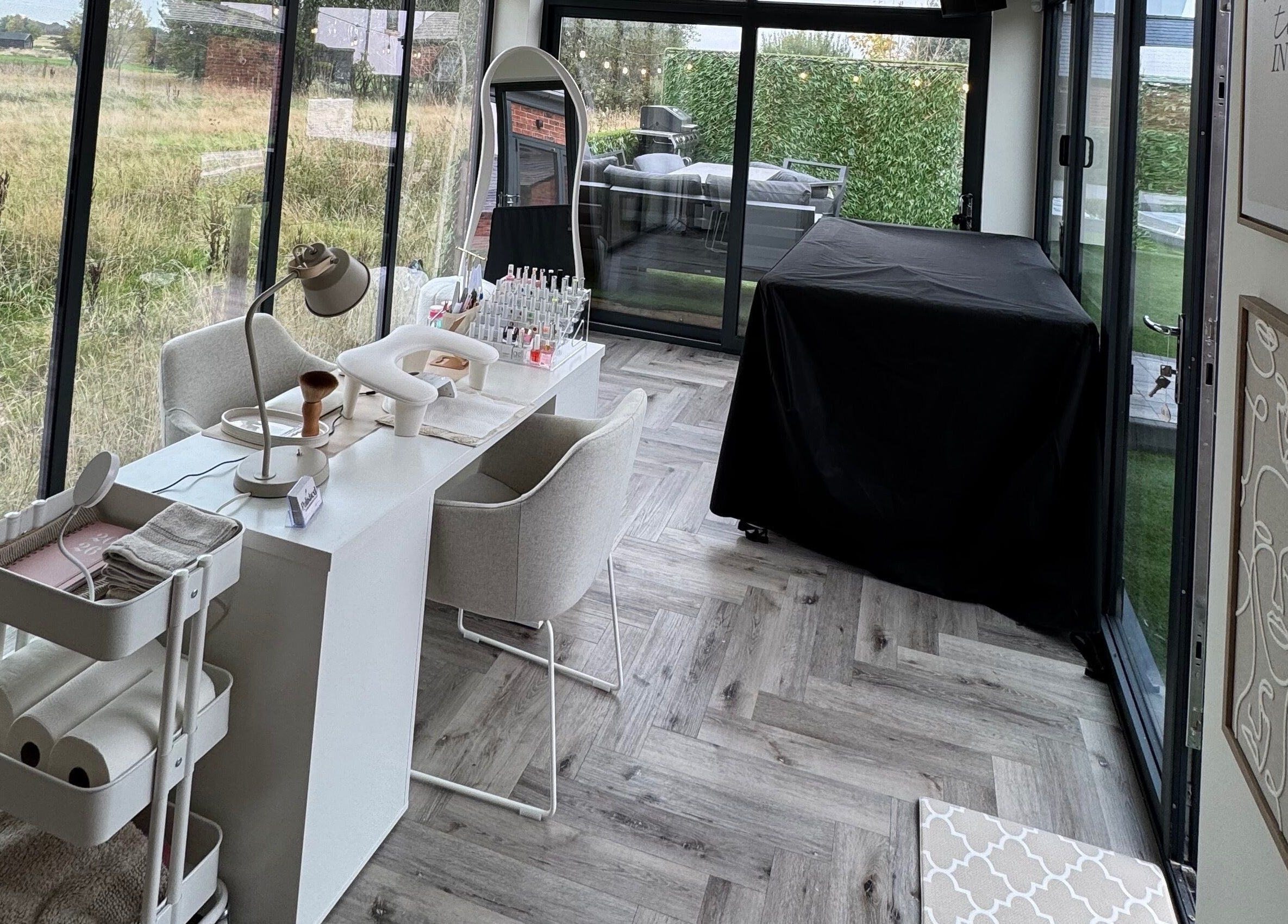 Chic nail studio setup at Polished By Poppy, Unsworth, England, GB, with modern decor and lush garden views.