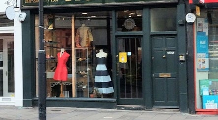 Front view of Jenelle Thompson hair @ Giovanni’s, boutique exterior in London, England, GB showcasing stylish dresses.