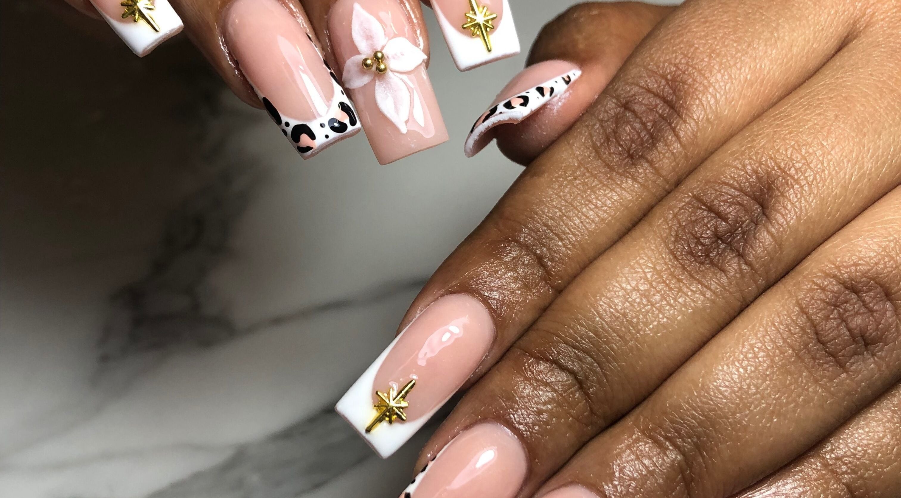 Elegant nail designs with floral and star accents at Blucloud Beauty, Windhoek, Khomas Region, NA.