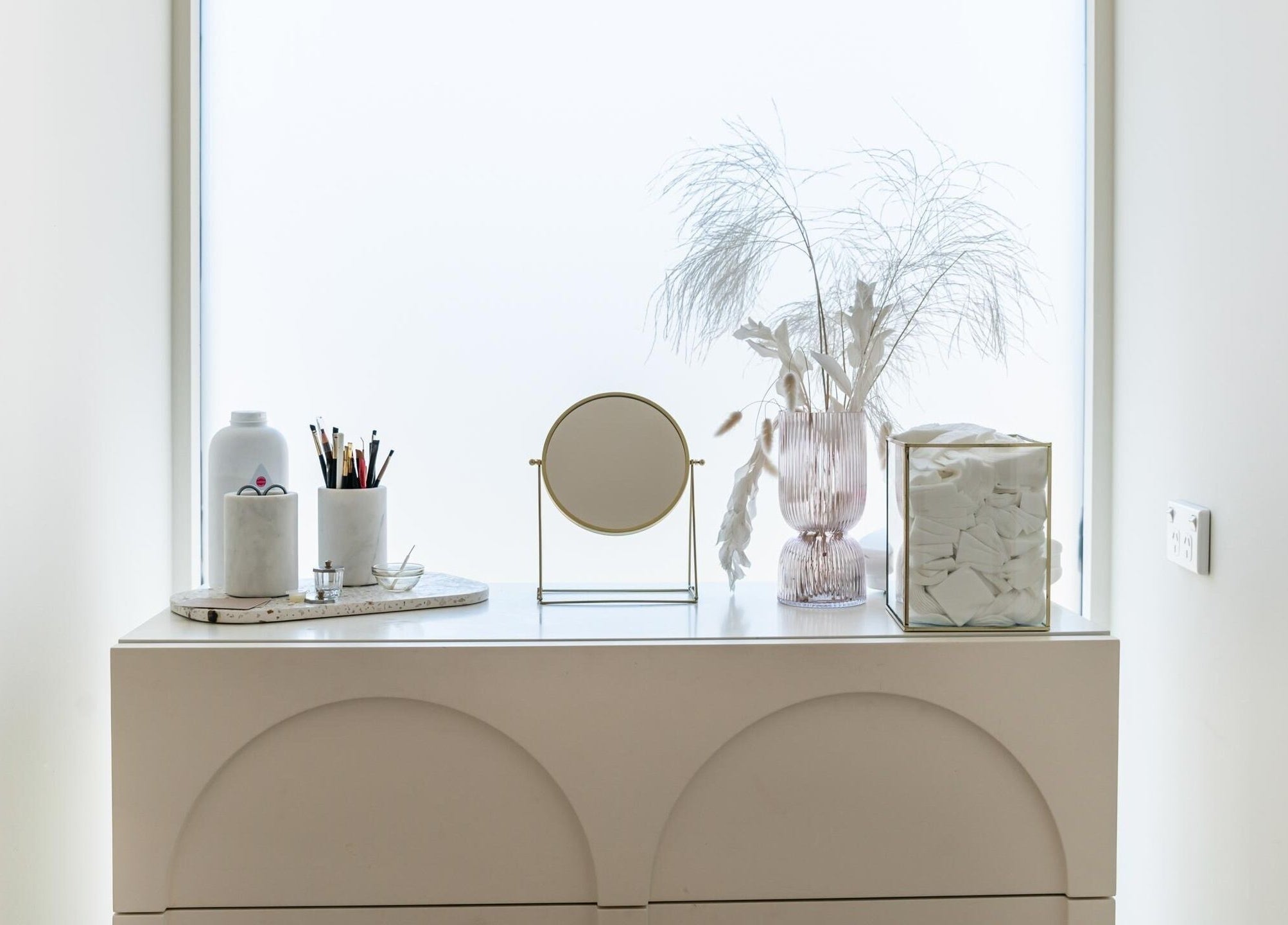 Elegant vanity setup at Laque Collective Ladies Salon, Dubai, Dubai, AE with mirror, brushes, and decor.