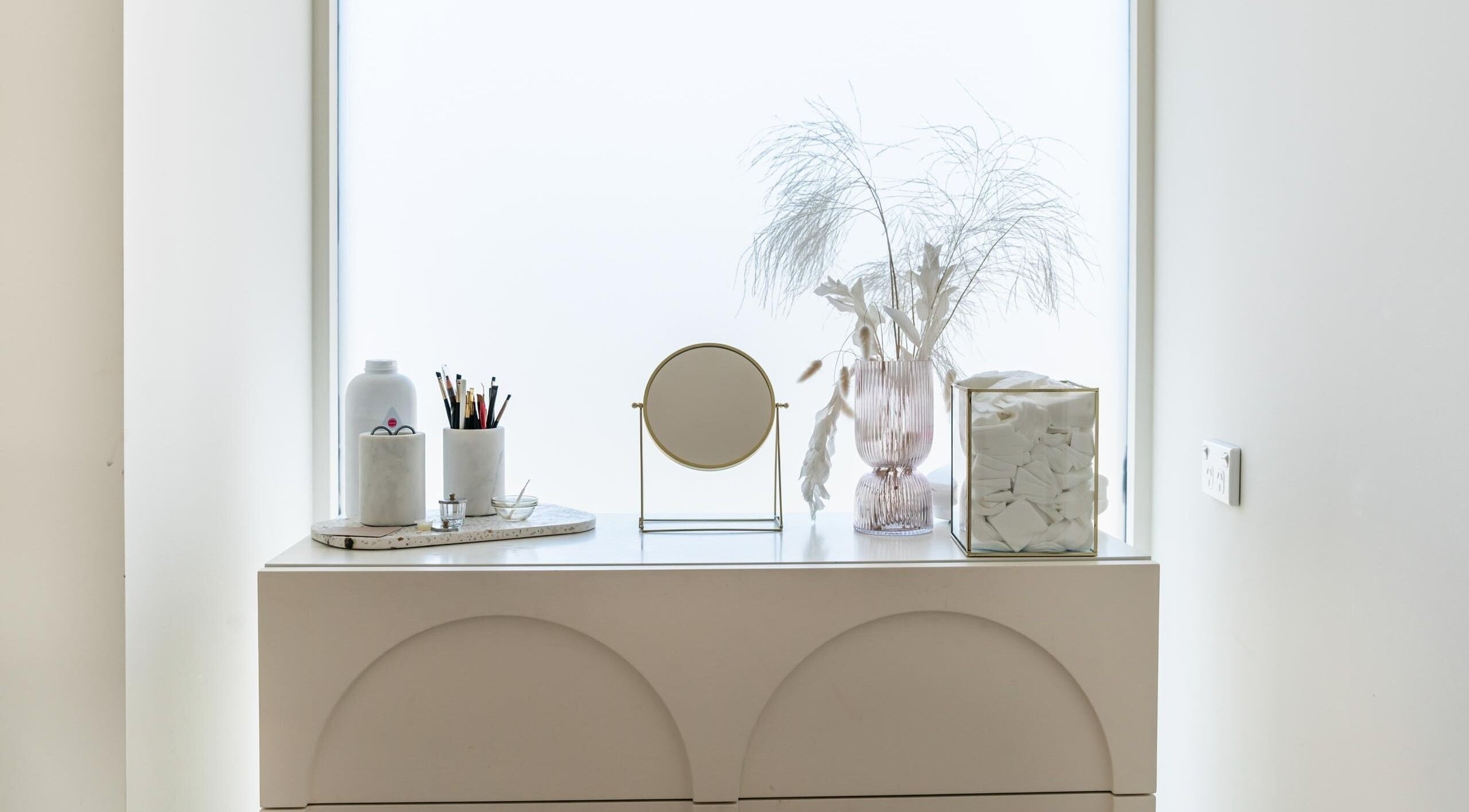 Elegant vanity setup at Laque Collective Ladies Salon, Dubai, Dubai, AE with mirror, brushes, and decor.