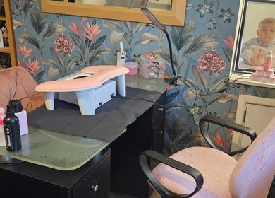 Stylish nail station at Kawaii Nails, Neath, Wales, GB with floral wallpaper and manicure tools.