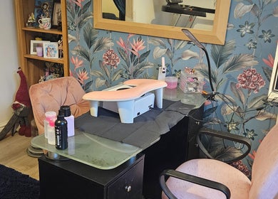 Nail station with pink armrest at Kawaii Nails, Neath, Wales, GB featuring floral wallpaper.