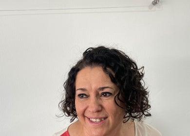 Smiling woman with curly hair at Kimiko Hair Studio, Pretoria, Gauteng, ZA.