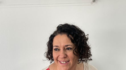 Smiling woman with curly hair at Kimiko Hair Studio, Pretoria, Gauteng, ZA.