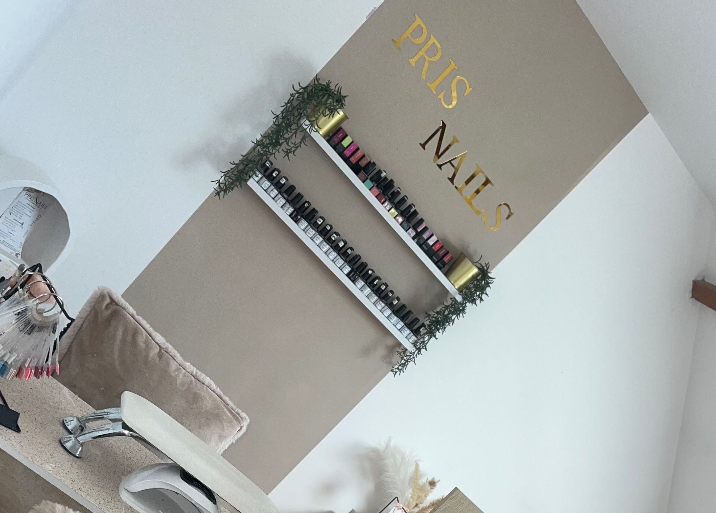 Intérieur de Pris Nails à Bourg-beaudouin, Normandie, FR, avec des vernis colorés et un design élégant.