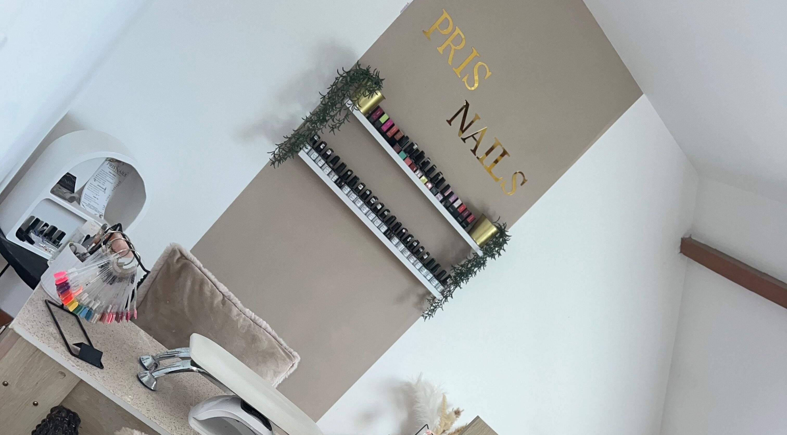 Intérieur de Pris Nails à Bourg-beaudouin, Normandie, FR, avec des vernis colorés et un design élégant.