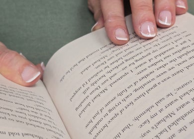 Manos con manicura francesa sostienen un libro en Almalibre Beauty Atelier, Majadahonda, Comunidad De Madrid, ES.