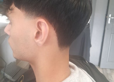 Clean taper haircut at RA FADE BARBERS, London, England, GB, showcasing skilled barbering techniques.