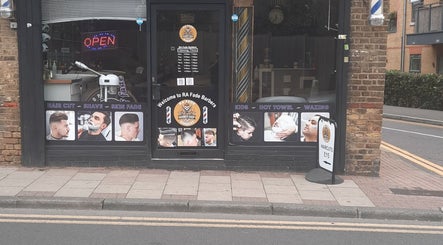 Exterior of RA FADE BARBERS in London, England, GB showcasing hair services and opening hours.