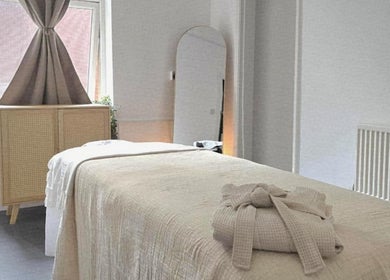 A tranquil treatment room at Santara Thai Wellness in Salford, England, GB, featuring a massage table and soft lighting.
