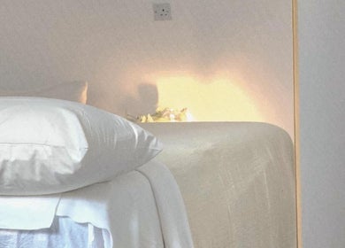 Peaceful massage room at Santara Thai Wellness in Salford, England, GB, featuring soft lighting and cozy bedding.
