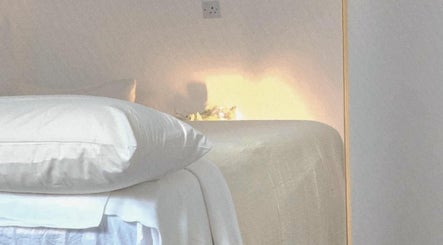 Peaceful massage room at Santara Thai Wellness in Salford, England, GB, featuring soft lighting and cozy bedding.