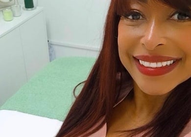 Smiling woman in treatment room at Lucy’s Spa in Dublin, County Dublin, IE, showcasing relaxing ambiance.