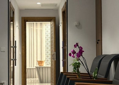 Elegant waiting area at Let's Relax My Spa, İstanbul, TR, featuring comfortable seating and vibrant orchids.
