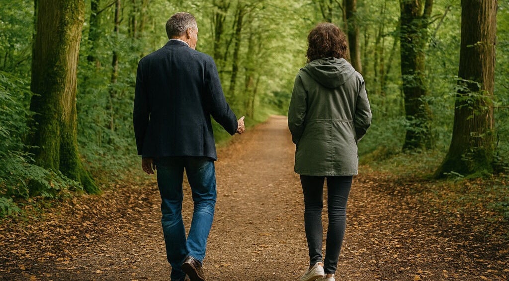 Two individuals walking a forested path near Whistley Therapies, Potterne, England, GB.