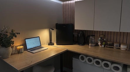 Silk Touch Tattoos cozy workspace in Colchester, England, GB featuring a laptop and decor.