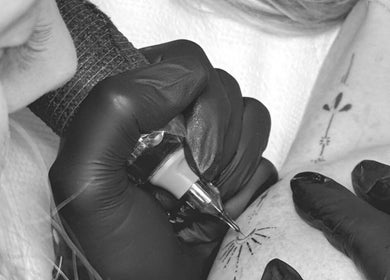Artist creating tattoo at Silk Touch Tattoos, Colchester, England, GB, showcasing precision in body art.