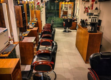 Interior de Pelizzari Barbershop - Parque Patricios en Buenos Aires, con sillas y espejos elegantes.