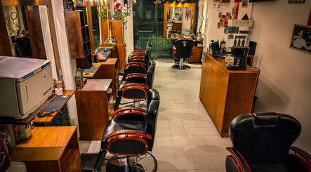 Interior de Pelizzari Barbershop - Parque Patricios en Buenos Aires, con sillas y espejos elegantes.