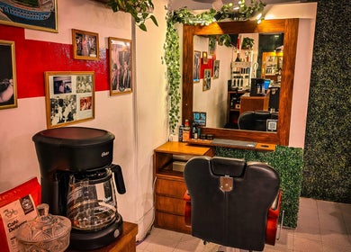 Interior de Pelizzari Barbershop - Parque Patricios en Buenos Aires, destacando una silla y un espejo decorado.