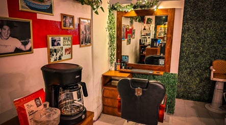 Interior de Pelizzari Barbershop - Parque Patricios en Buenos Aires, destacando una silla y un espejo decorado.
